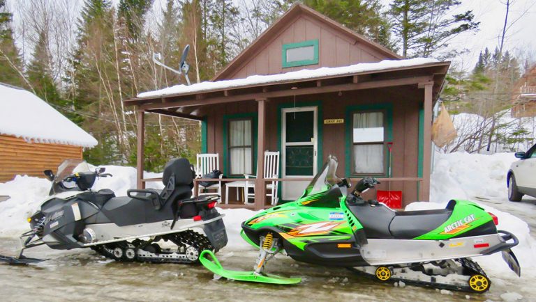 snowmobiles in front of cabin during winter at Lopstick