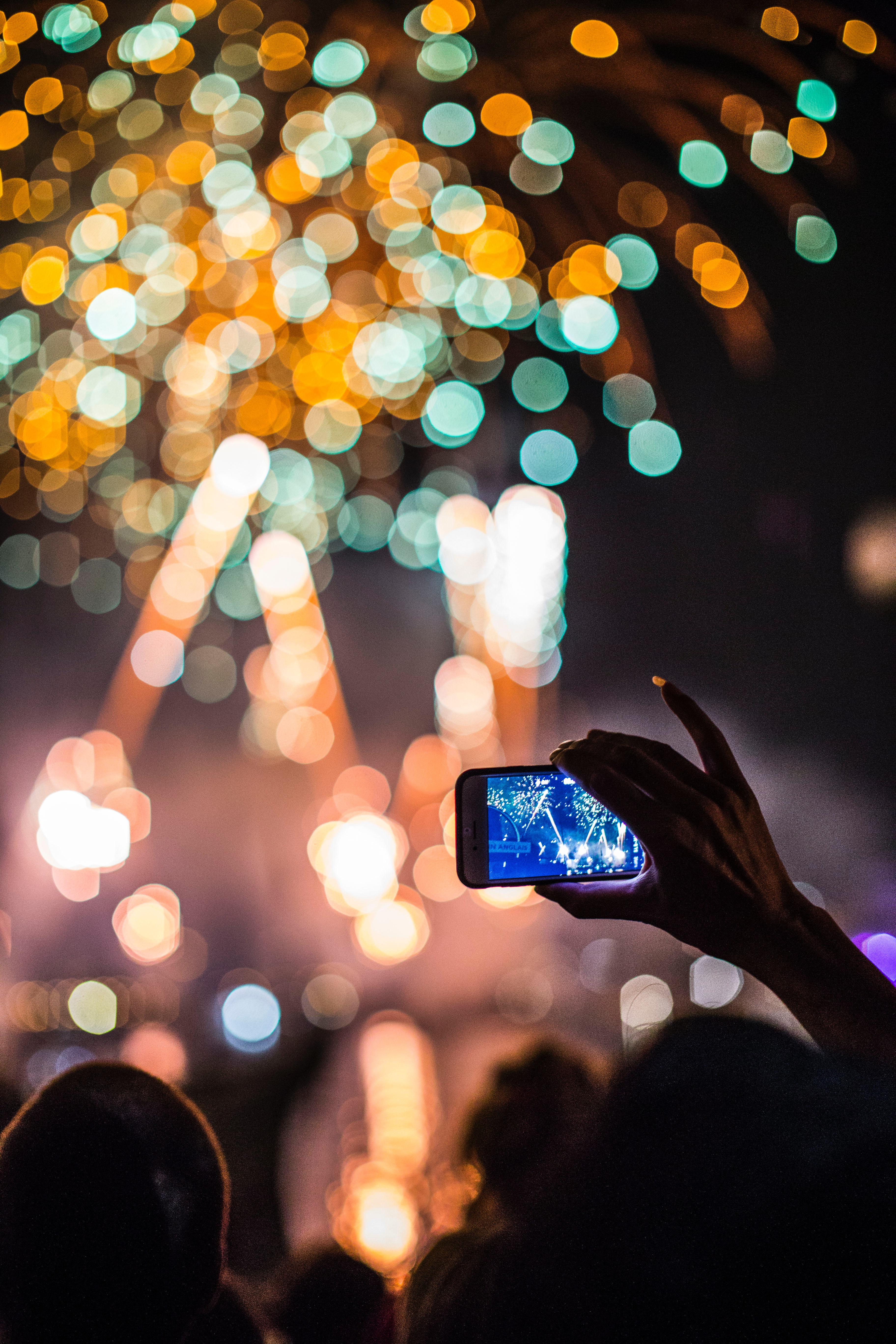Person holding phone to capture fireworks