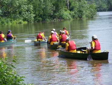 Group of people padding along a river in the North Country